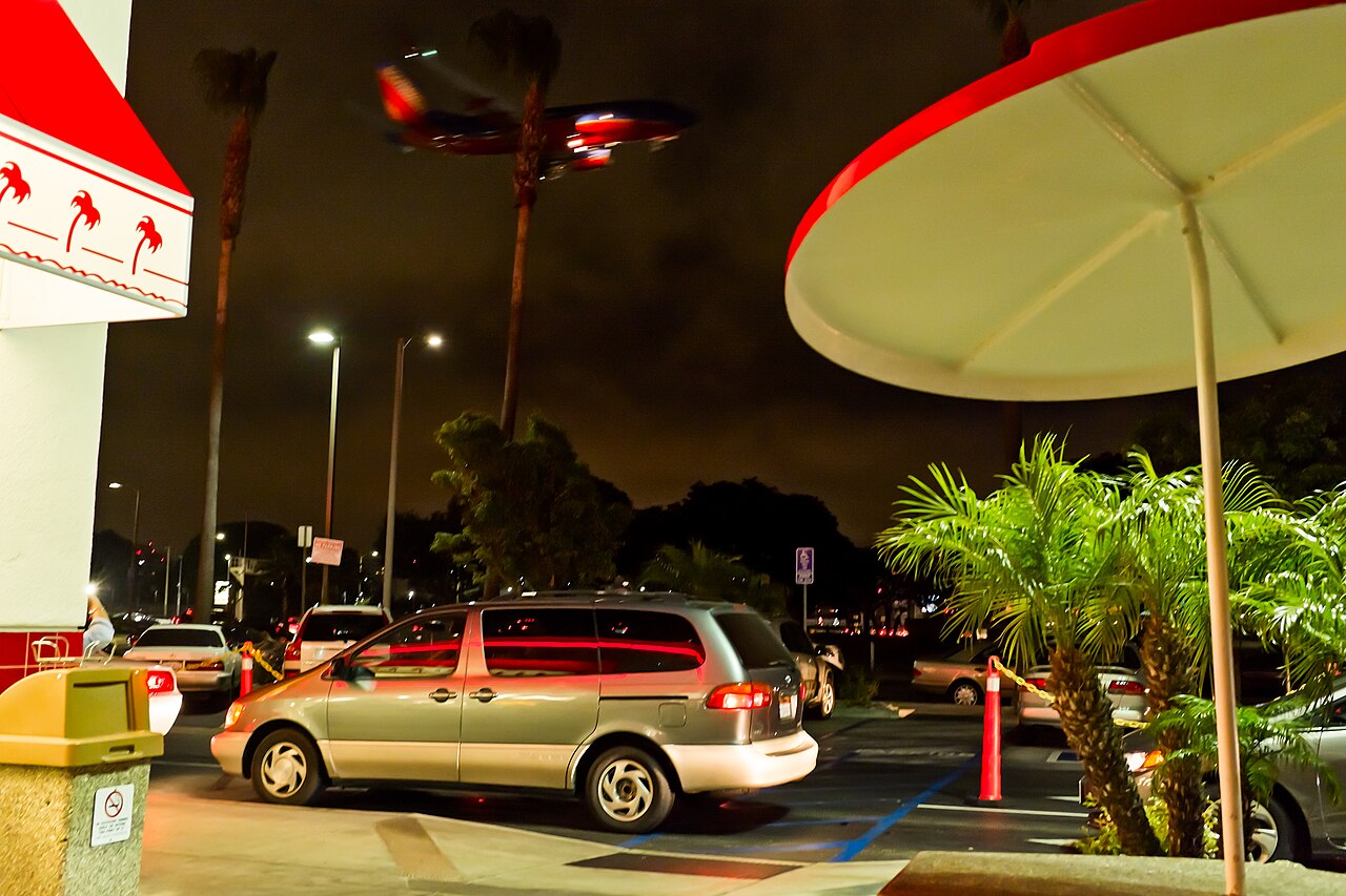 A Southwest Airlines plane landing at LAX, seen from a nearby parking lot