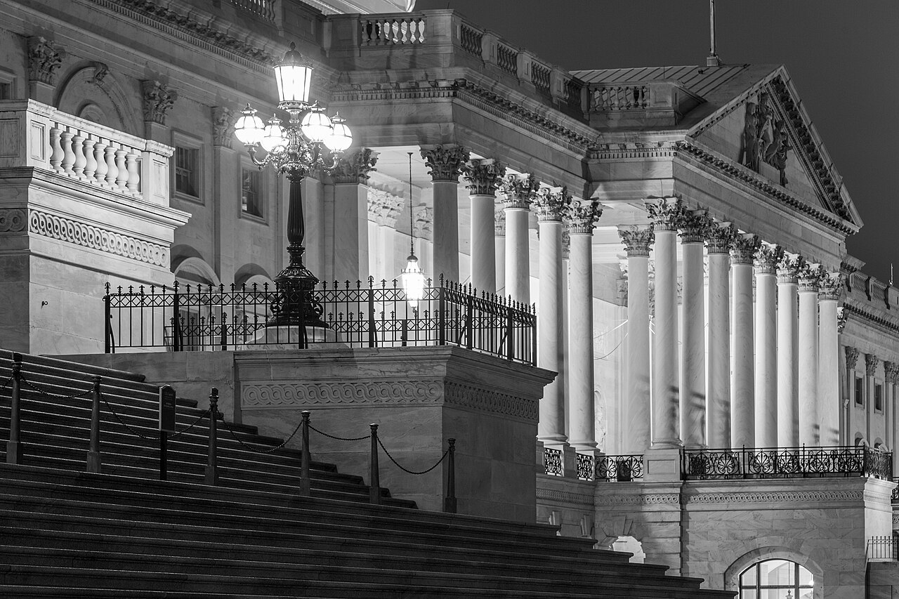 The U.S. Capitol at night, lit columns and lamp