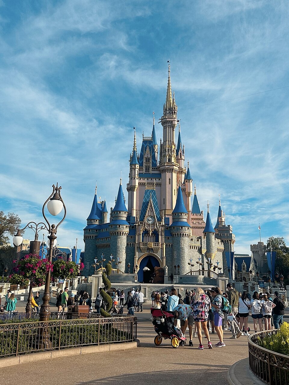 Cinderella Castle at Magic Kingdom under a blue sky with guests in the foreground
