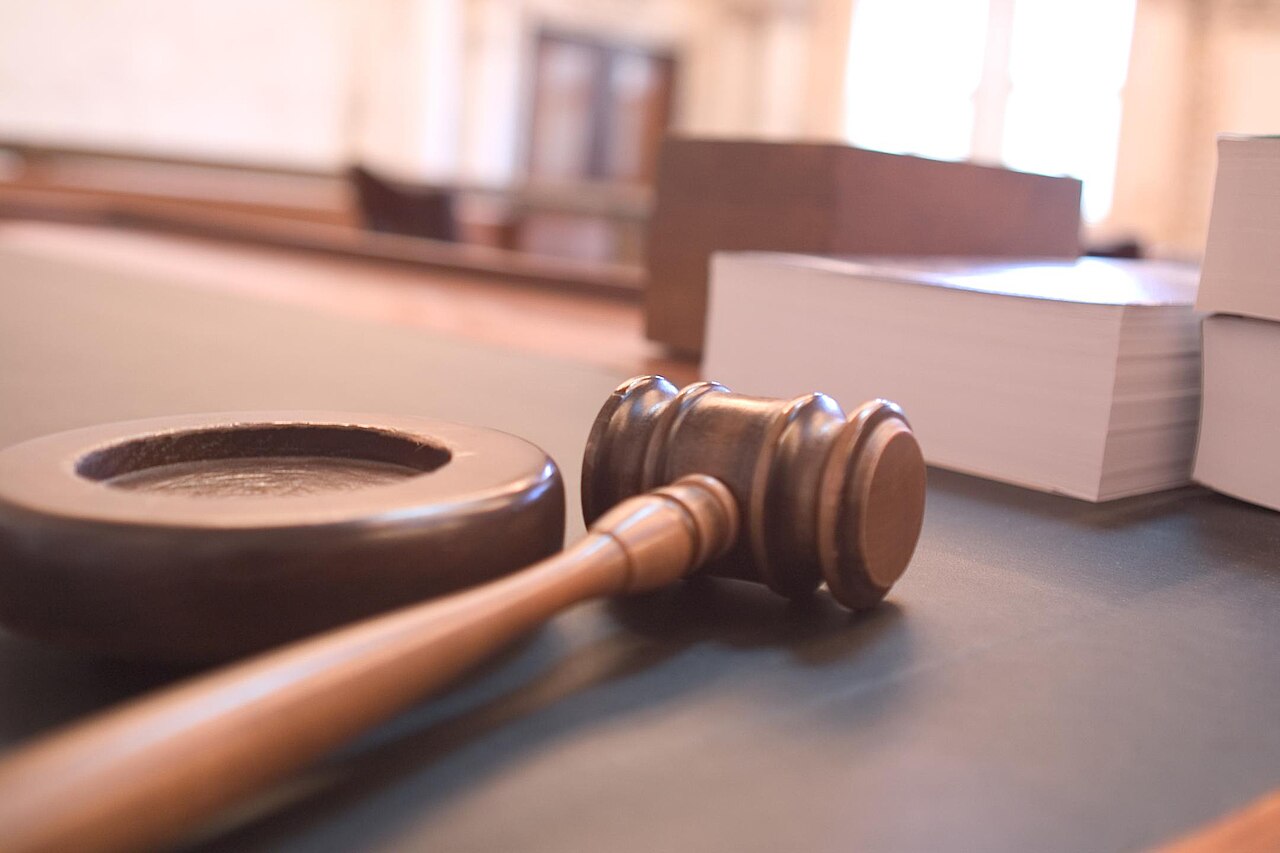 A judge's gavel resting on a courtroom desk